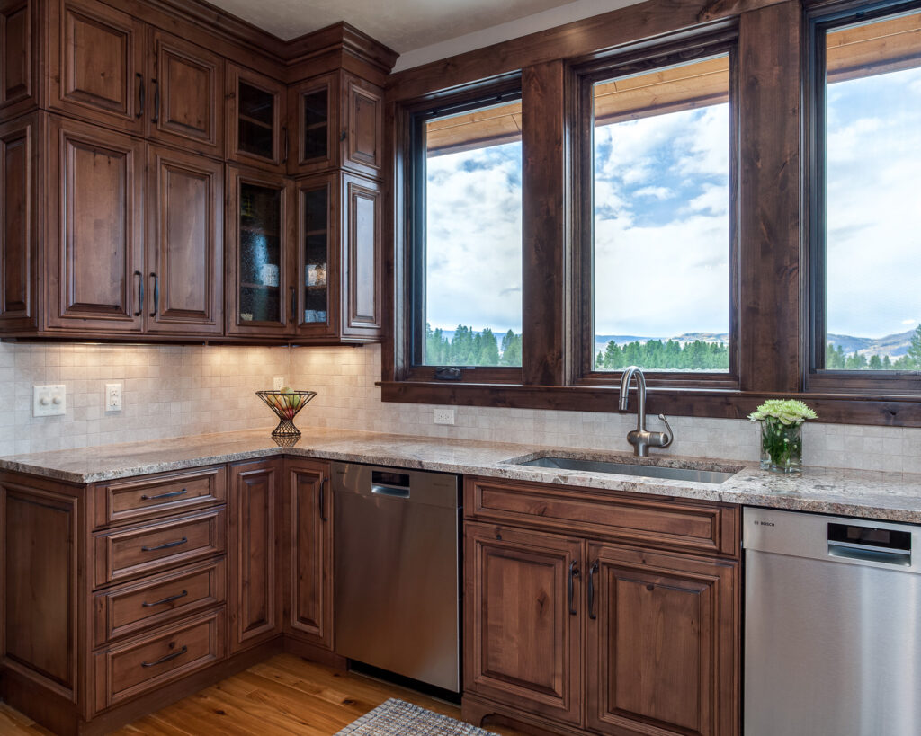 Mountain Home Kitchen with rustic alder wood cabinets frame windows of the views of Fraser valley colorado beyond
