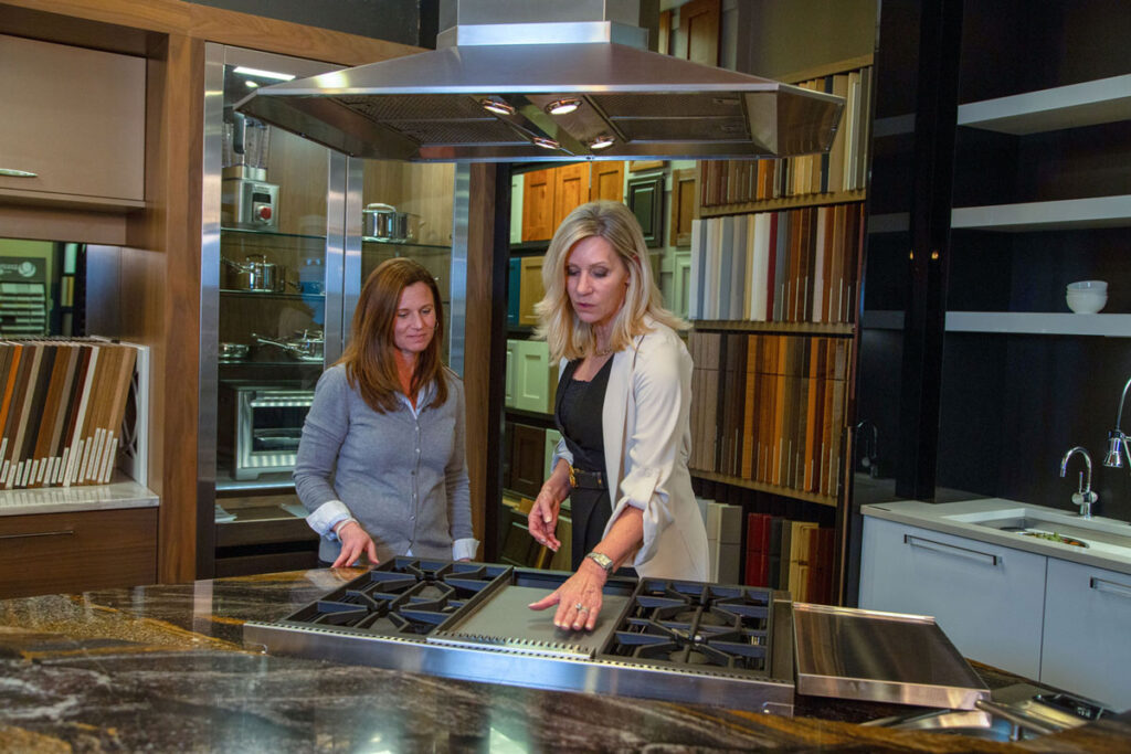 jm kitchen & bath Designer Juli shows customer choices in the showroom