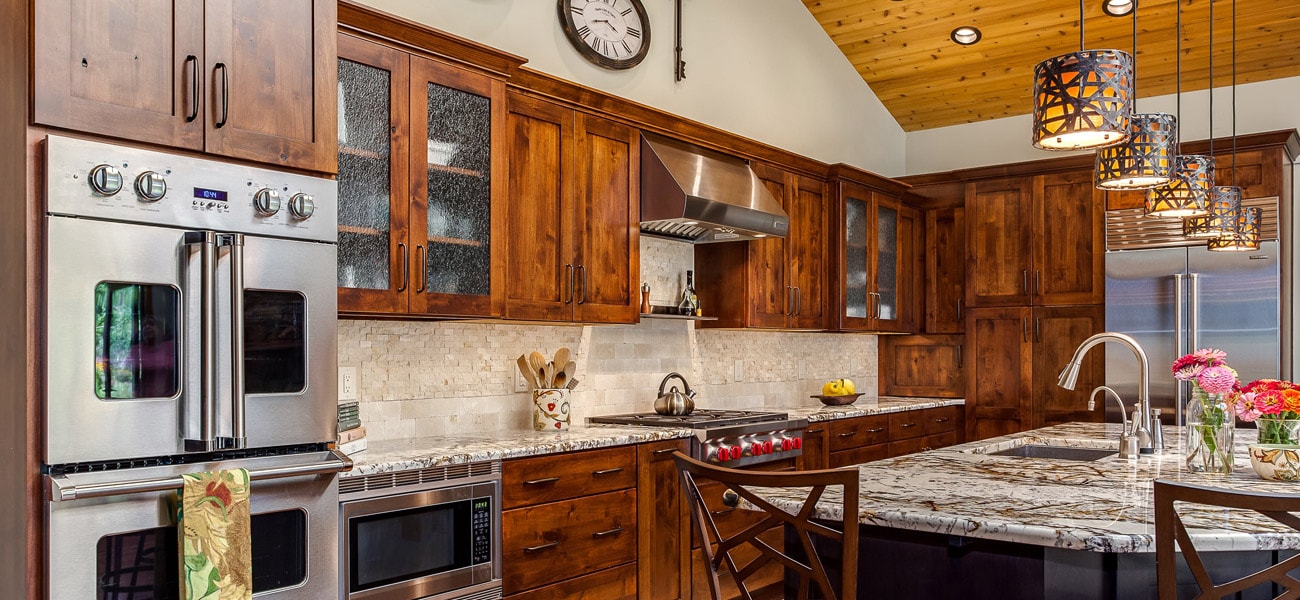 Rustic kitchen with natural wood cabinets stainless range hood and appliances