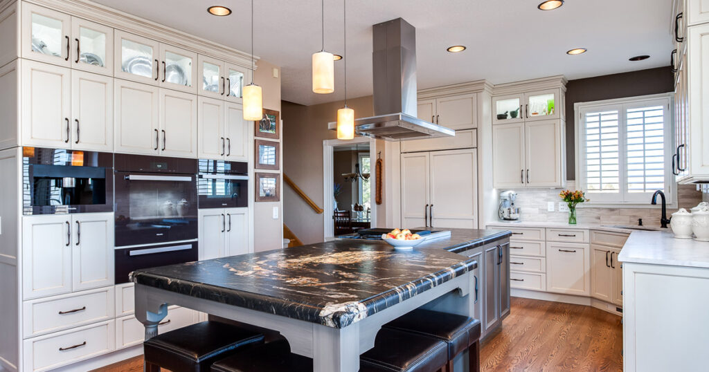 White painted cabinets with grey center kitchen islands one with seating stove top and one with stove top and hood