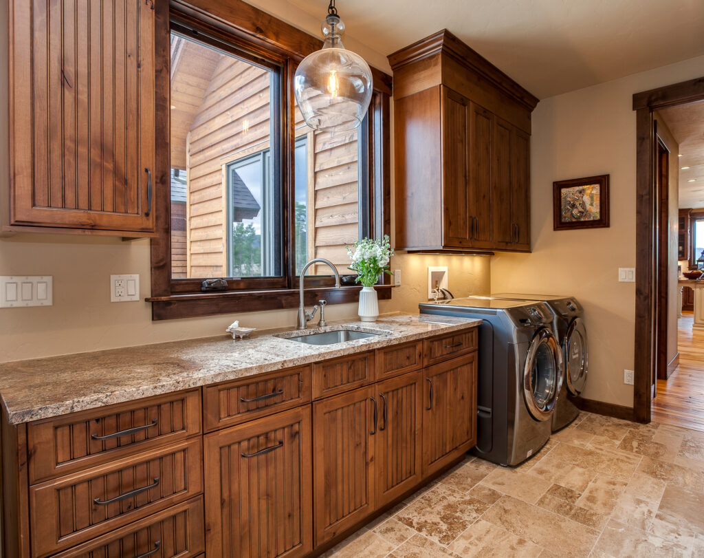 wood cabinets and utility sink in large laundry room
