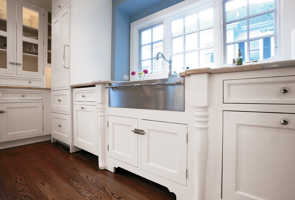 Painted white shaker kitchen cabinet with stainless knob pulls and stainless farm sink photo